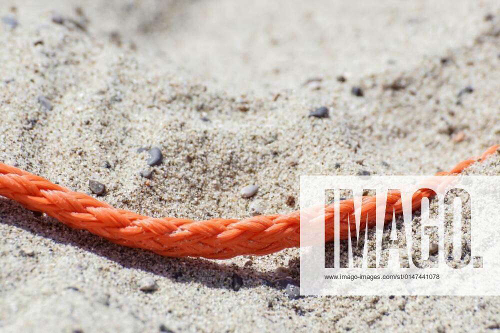 Old thick nautical rope on the sand ground