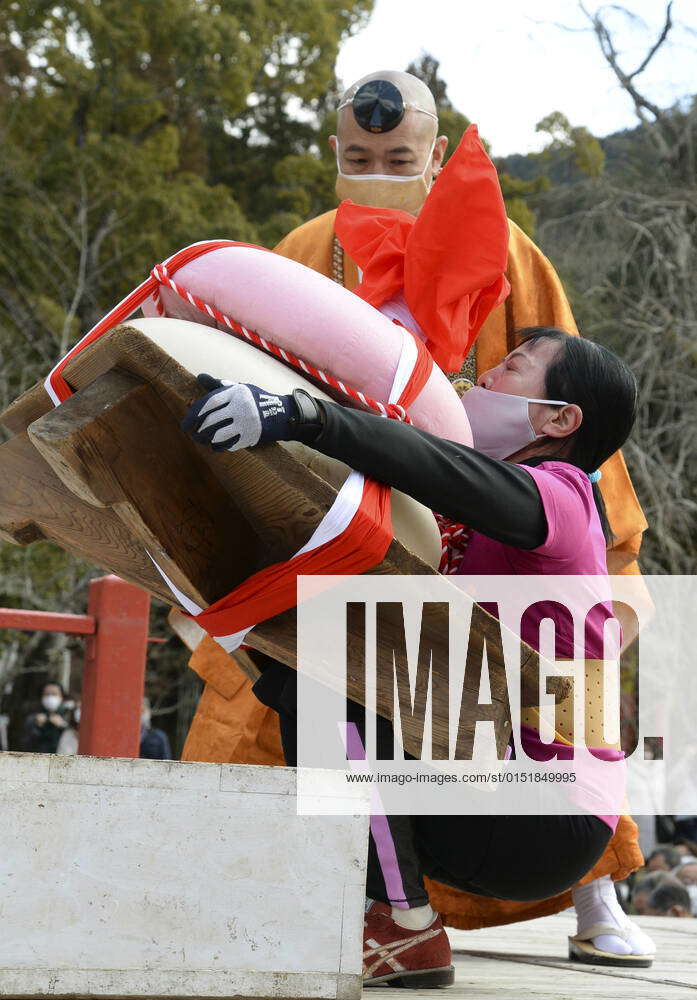Rice cake lifting at Kyoto temple A woman tries to lift up giant rice