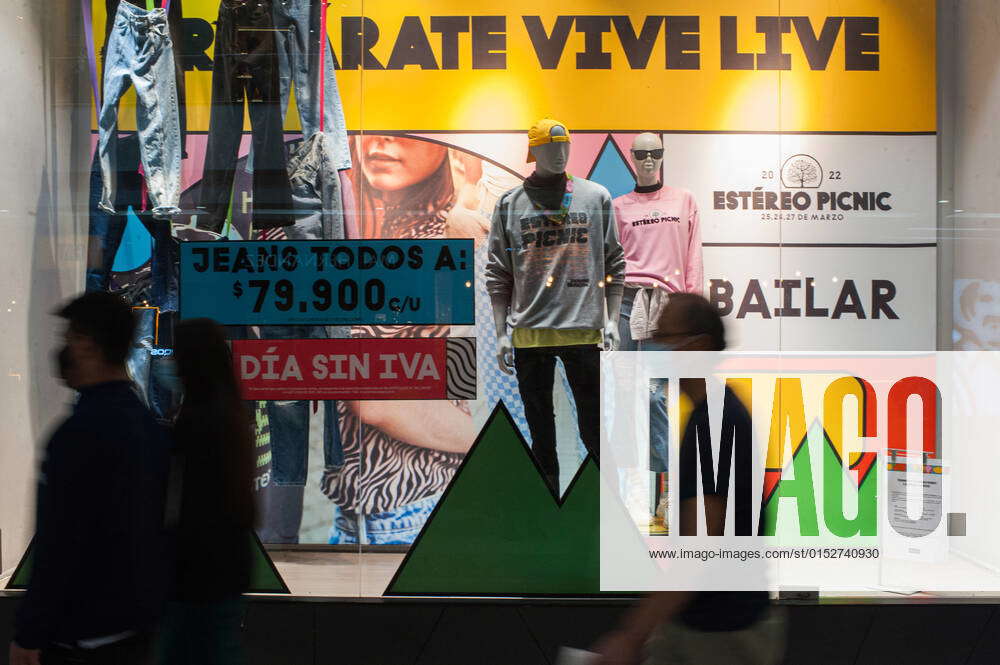 People pass by a clothing display that reads VATFree day (Dia Sin IVA