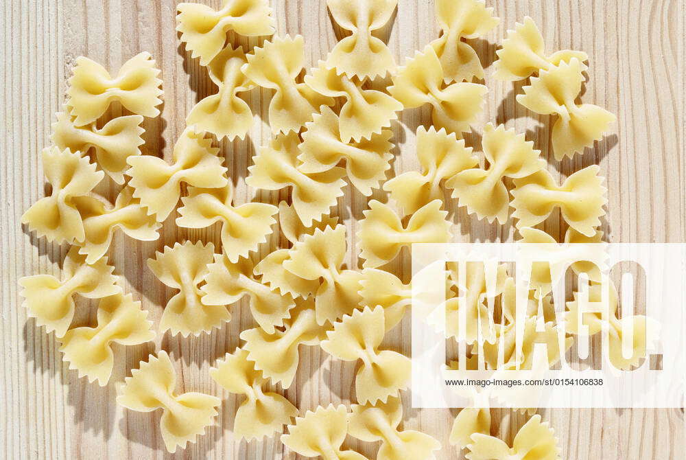 Dry pasta farfalle on wooden table , bowtie pasta or butterfly pasta