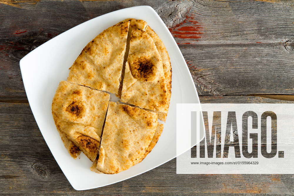 Overhead view of a crisp golden Naan flatbread baked in a traditional