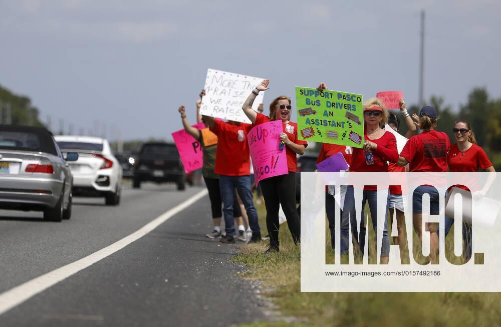 April 29, 2022, Land O Lakes, Florida, USA Pasco County Schools bus drivers wave and hold signs