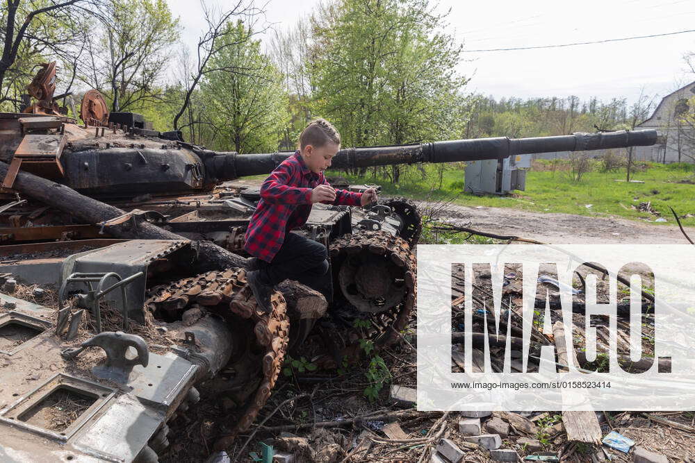 May 7, 2022, Kyiv, Ukraine: A boy plays on a burned Russian tank near ...