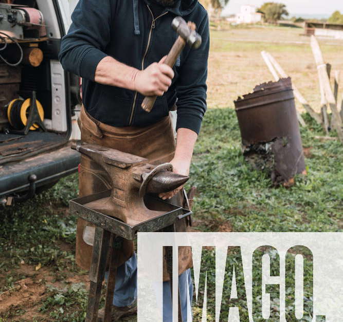 Worker in uniform horseshoe with hammer on metal anvil while