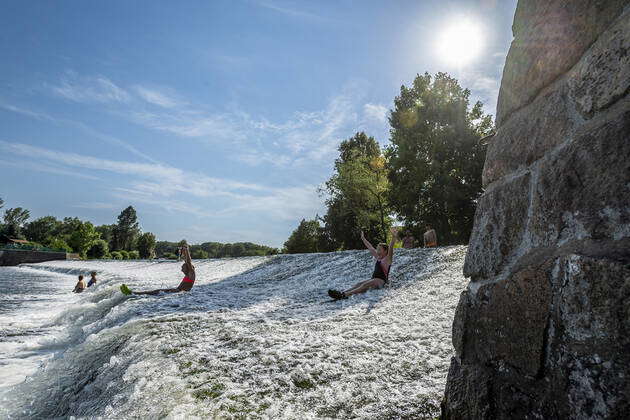 People enjoy cool water swimming at a weir on the Ohre River, Hostenice ...