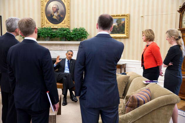 President Barack Obama talks with senior advisors following a meeting ...