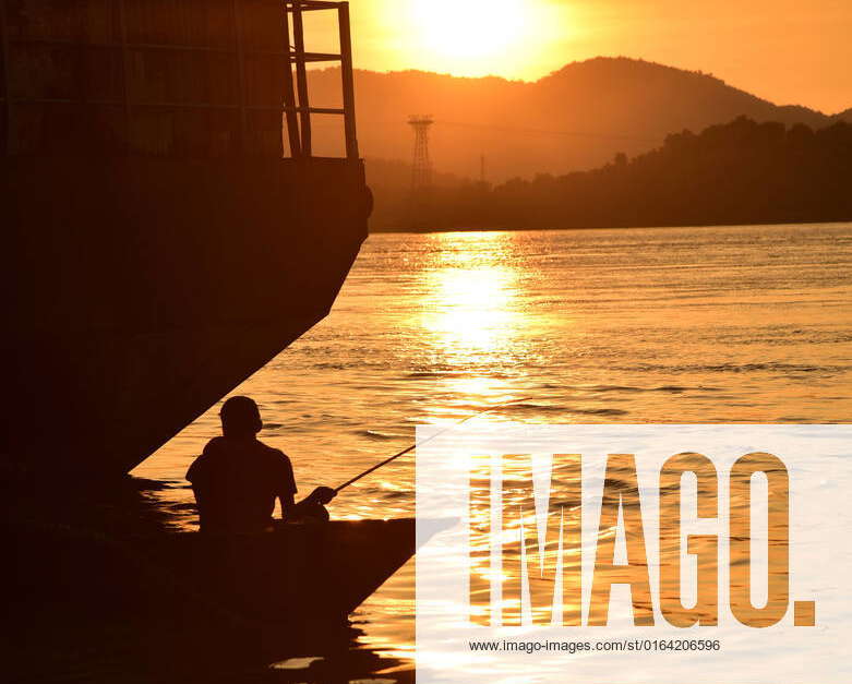 August 4, 2022, Guwahati, Guwahati, India A man fishing in river Brahmaputra during sunset in
