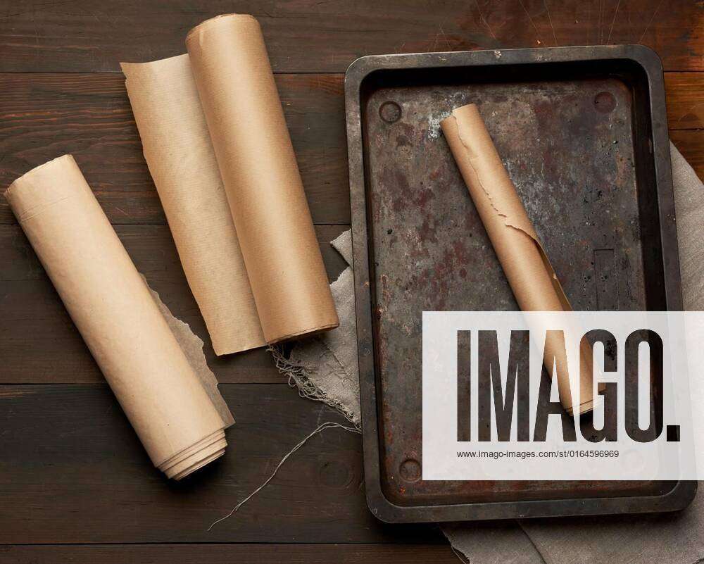 empty rectangular metal pan and rolls of brown parchment paper
