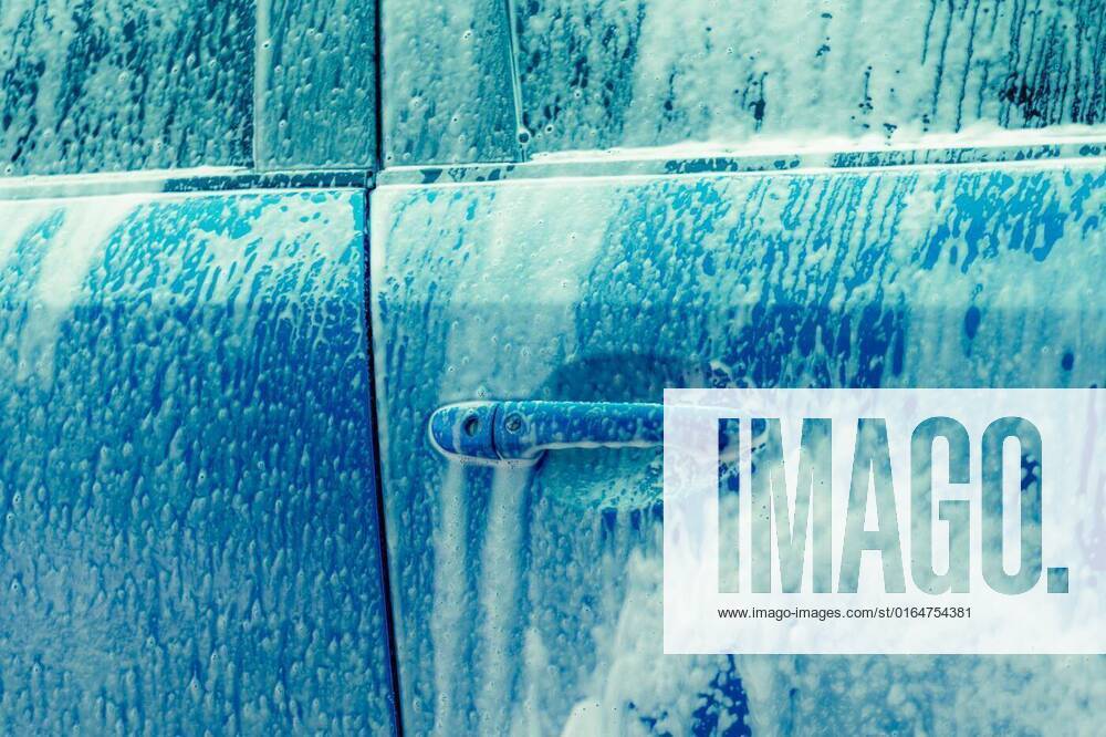 Blue car wash with white soap foam. Auto care business. Car cleaning