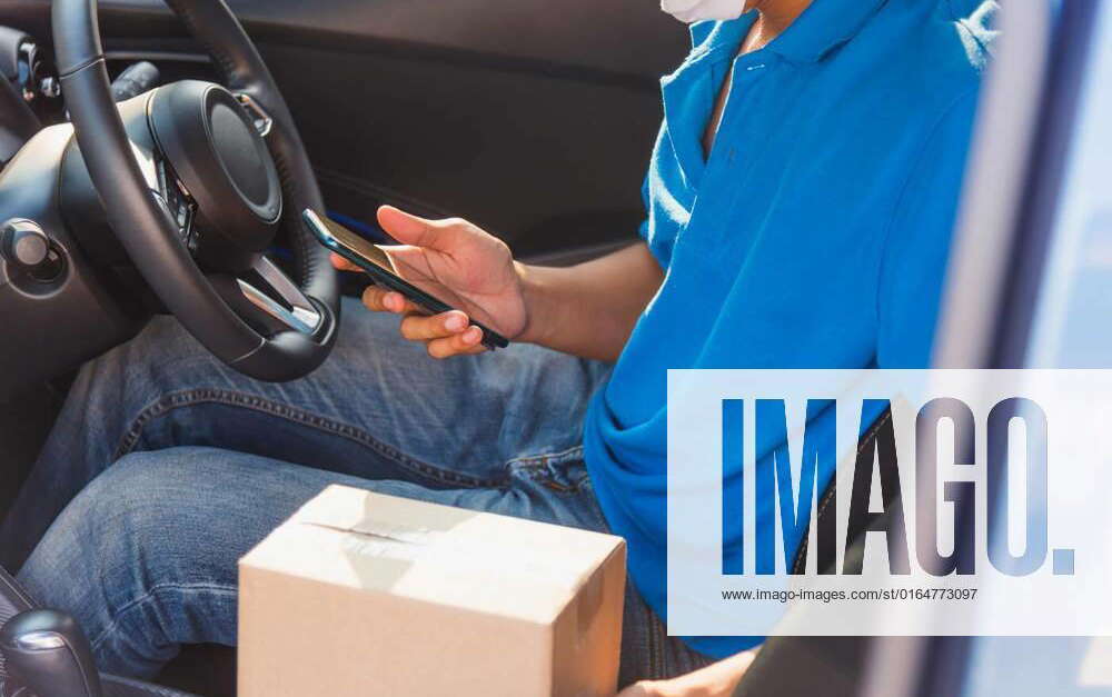 Delivery man courier holding deliveries out boxes and using mobile