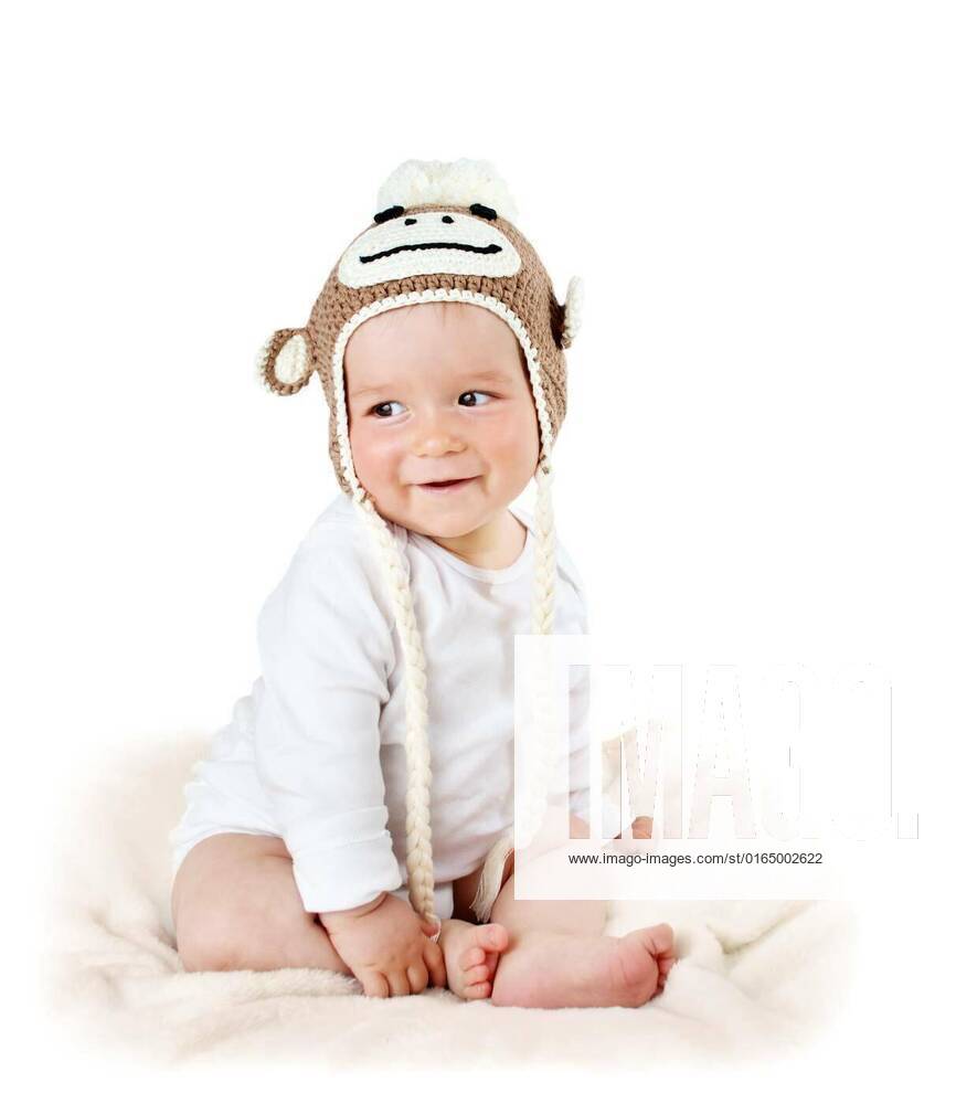 Baby in monkey hat, little baby in knitted monkey hat on brown blanket ...