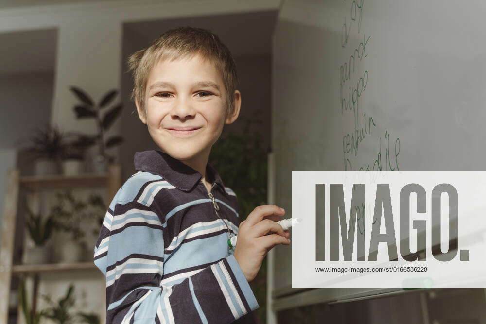 smiling-boy-with-felt-tip-pen-by-whiteboard-at-home-model-released