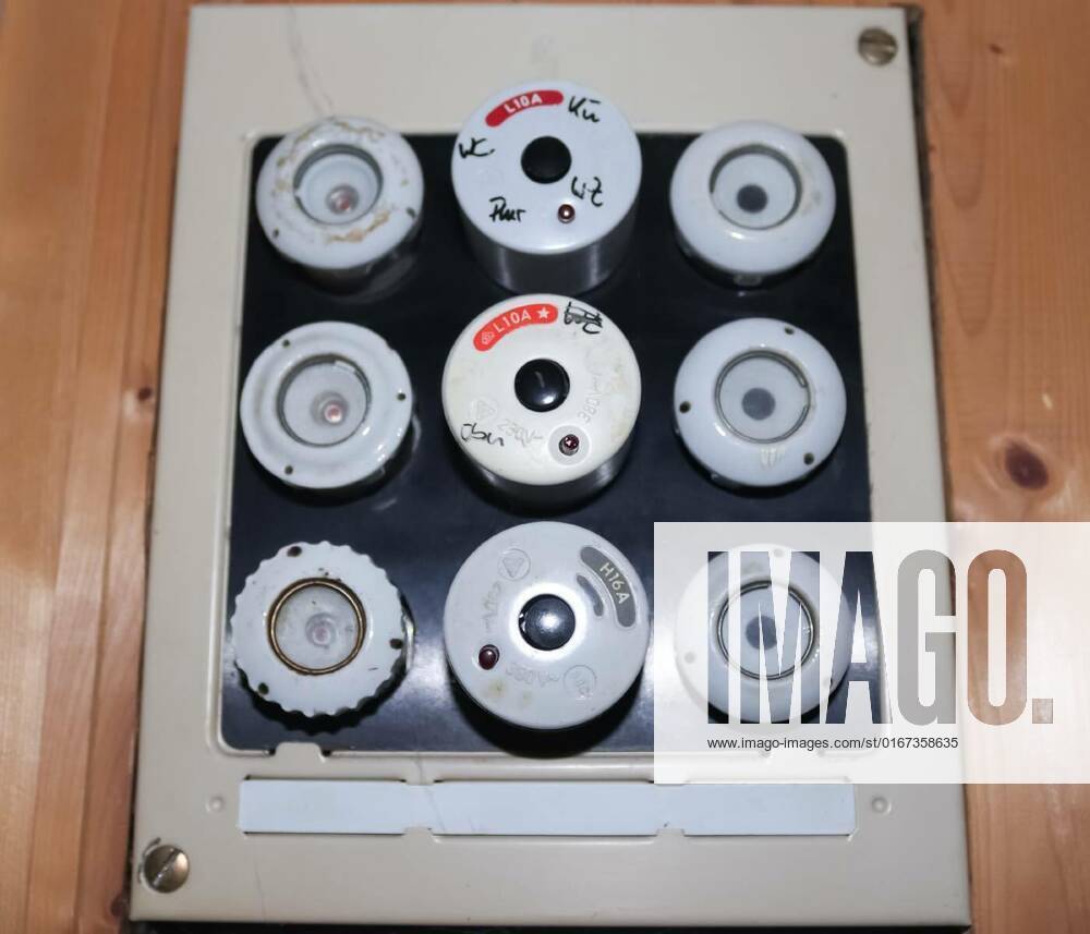 Old fuse box with ceramic fuses and some handwritings on it., Old fuse