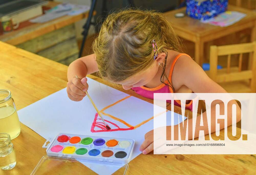 Little girl painting simple picture. Cute girl painting with