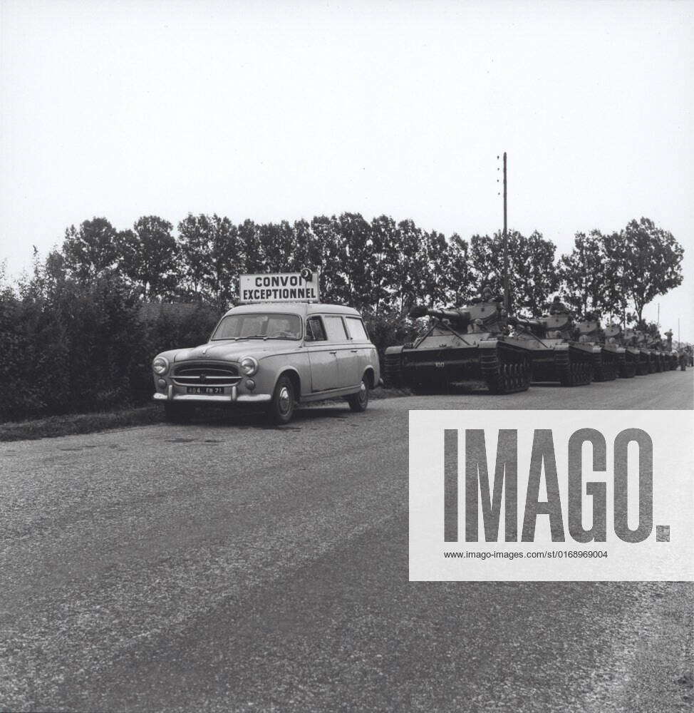 A column AMX-13 light tanks in France is preceded by a Peugeot 403 ...