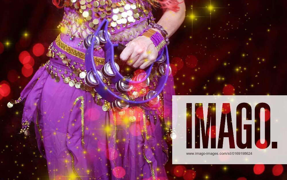 Belly Dancer wearing purple dance costume close up with bokeh, Belly