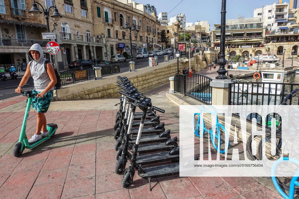 Daily Life In Malta Man riding Bolt e-scooter along parked shared ...