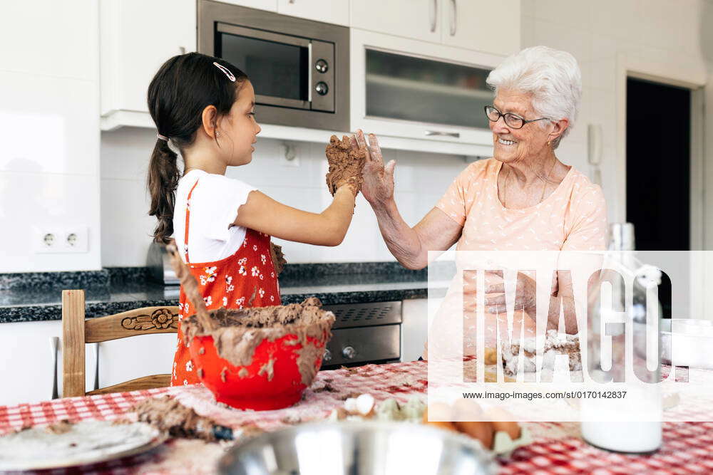 Cheerful grandma with granddaughter having fun while looking at each ...