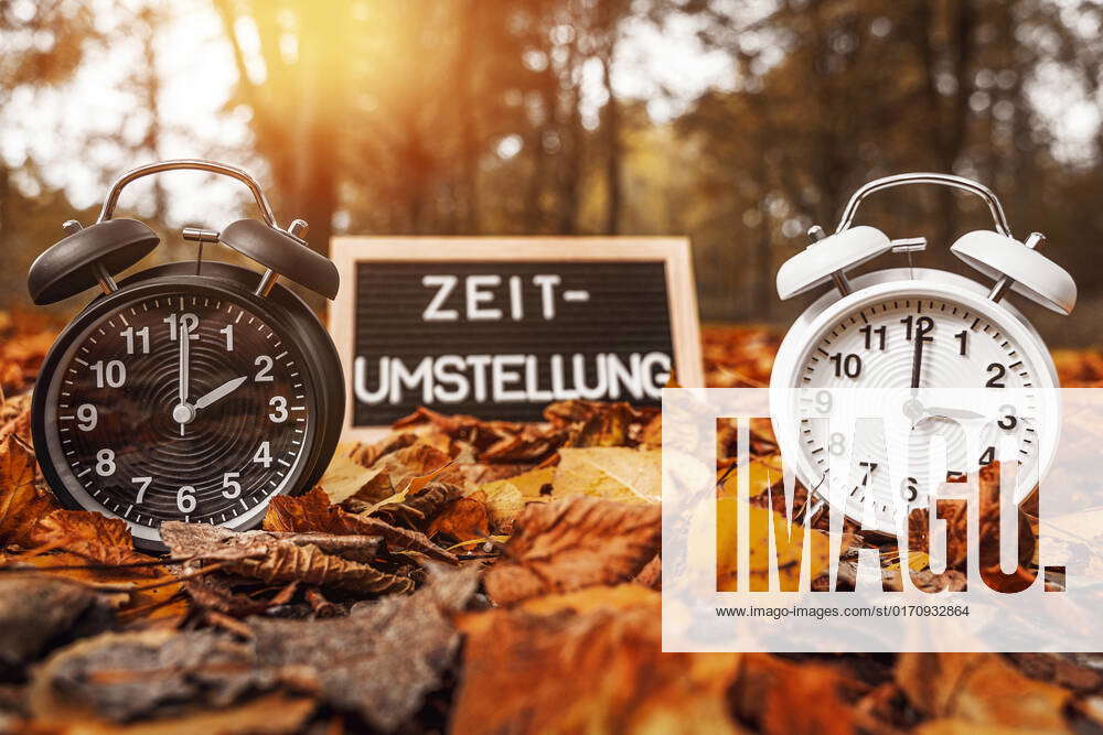 14 October 2022 Time change on a blackboard. Two alarm clocks with