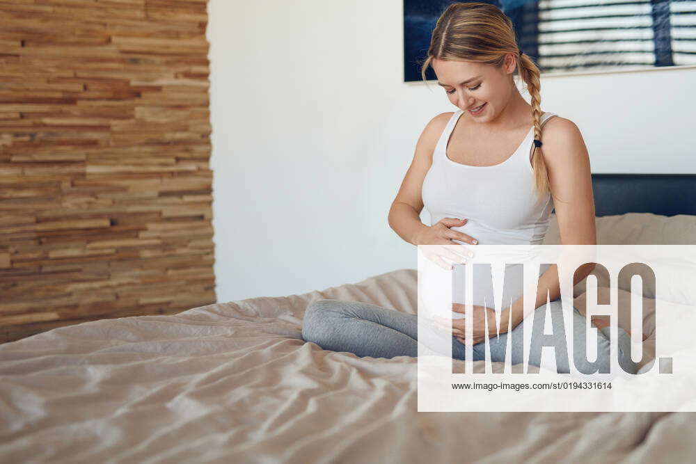 Junge Schwangere Frau Sitzt Auf Dem Bett Und Streichelt Ihren Bauch Happy Young Pregnant Woman 