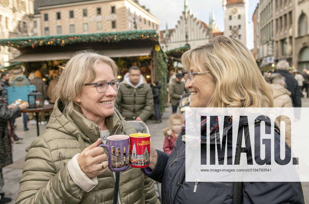 Two women drinking mulled wine at Munich Christmas market, Marienplatz, Munich, 21 November