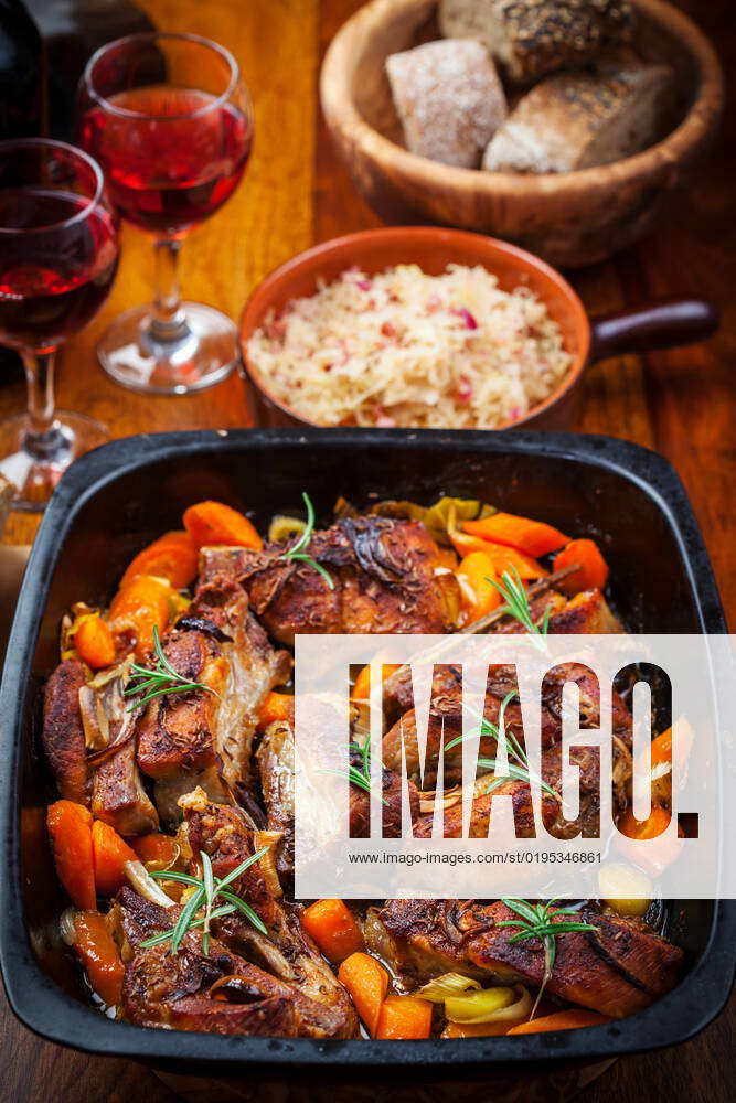 Roasted pork belly on vegetables with sauerkraut and red wine Roasted