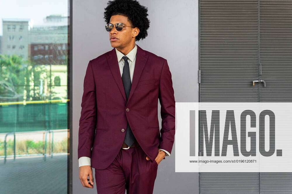 Villain Uensartet invadere Confident African American man in elegant bordeaux suit and sunglasses with  curly hair holding hand