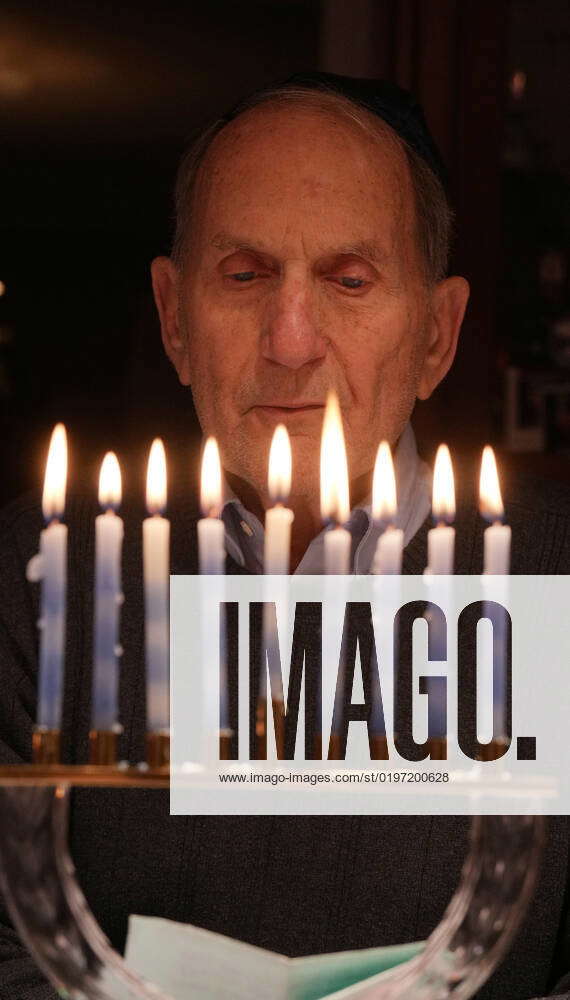 Martin Greenberg reads a prayer after lighting the eighth candle on the