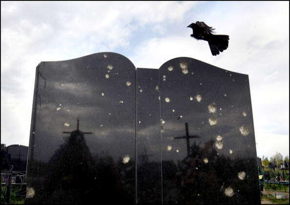 Bucha, Ukraine: Birds fly past a tombstone damaged by war in Bucha ...