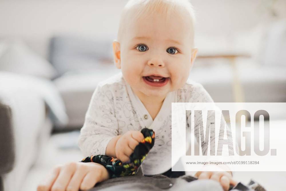 Cute infant baby boy playing, crawling and standing upat home. Baby ...