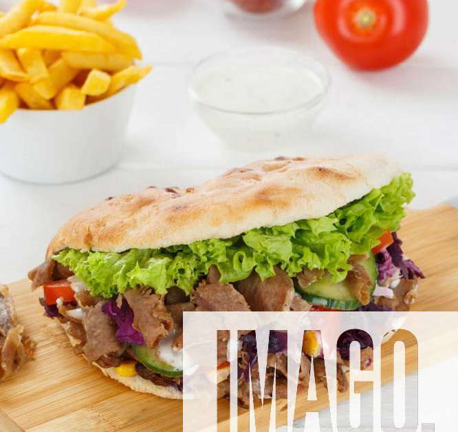 Döner Kebab Doner Kebap fast food meal in flatbread with fries on a kitchen board portrait format