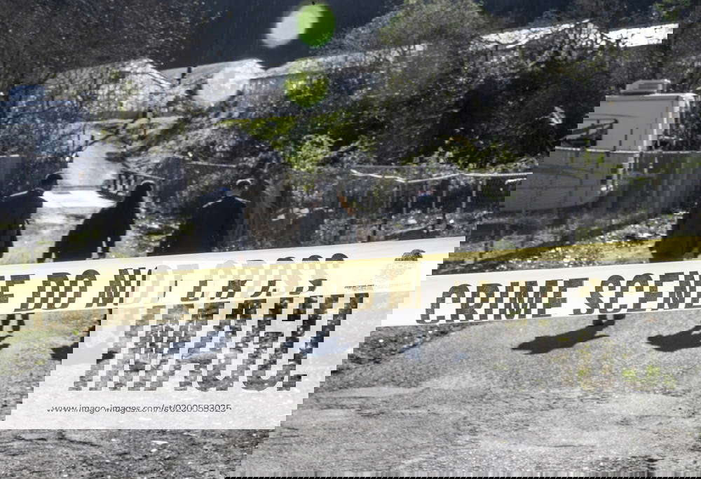 Law enforcement officers walk toward the scene of a mass shooting at Mountain Mushroom Farm in Half