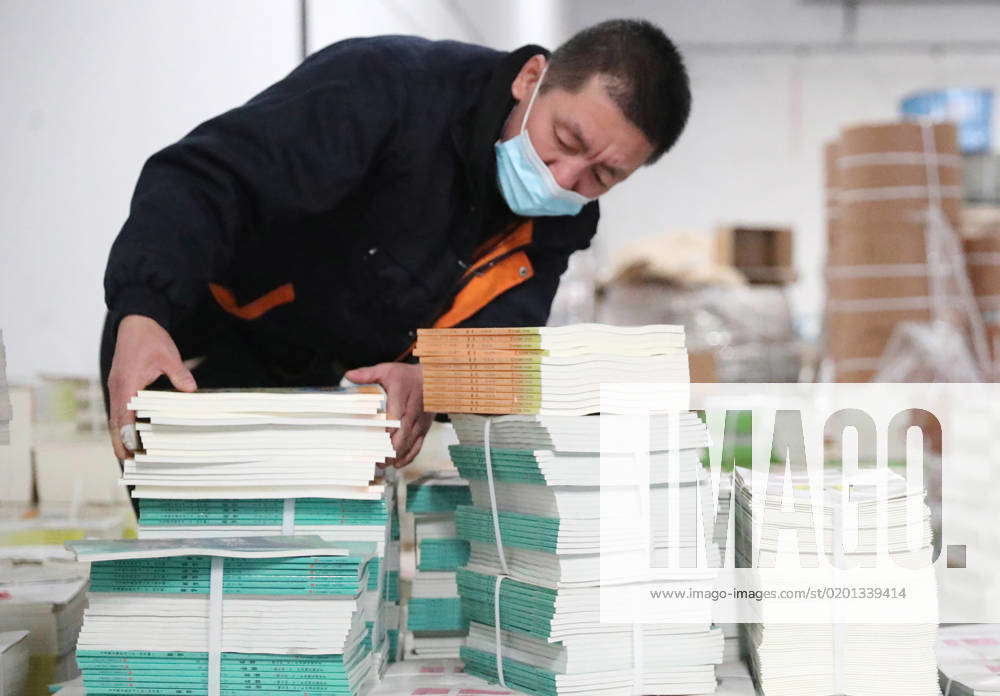 QINGDAO, CHINA - JANUARY 31: A staff member arranges textbooks to be ...