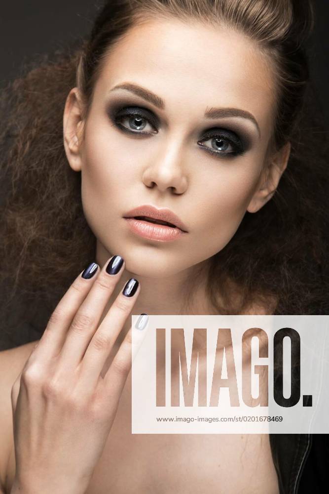 Beautiful girl in leather jacket with bright makeup and manicure Cat s