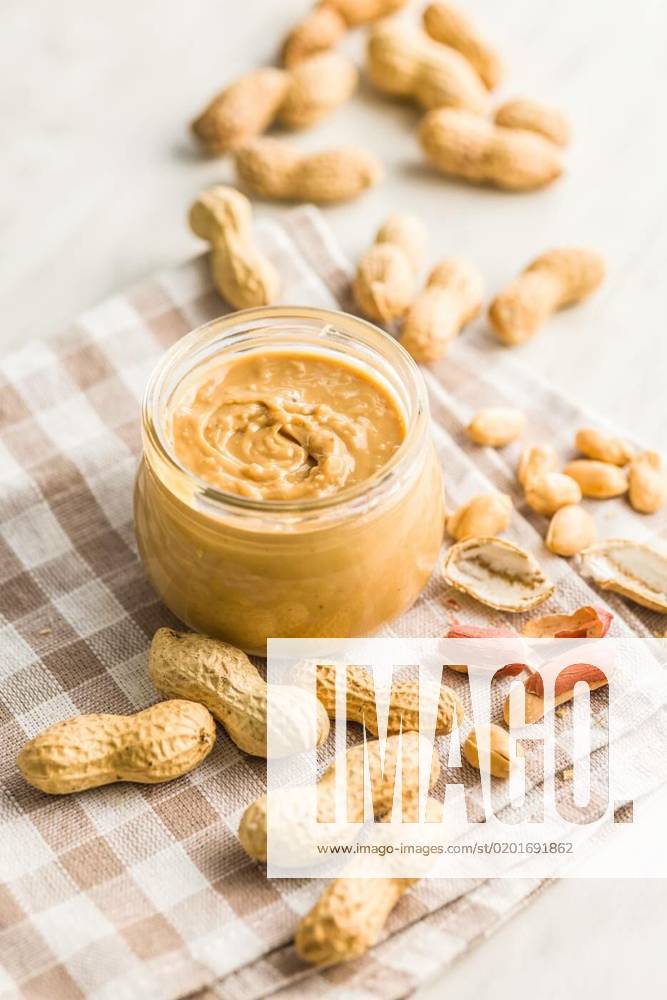 Peanut butter in jar on kitchen table., Peanut butter in jar on kitchen