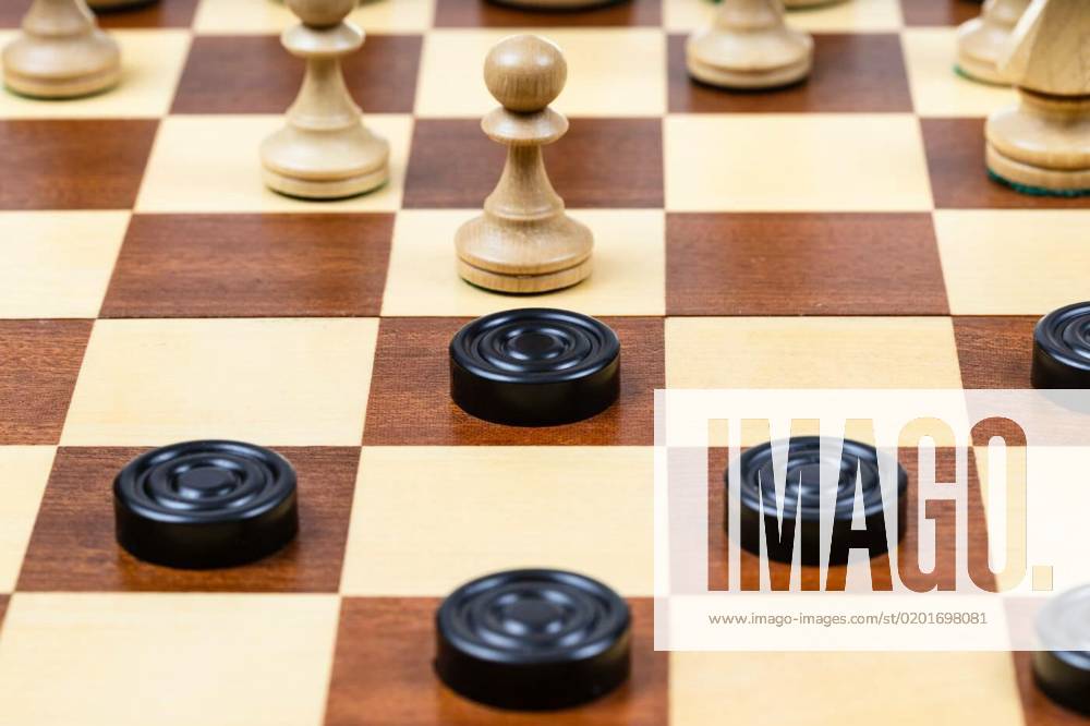 Pawn and checkers piece in center of board closeup, playing by