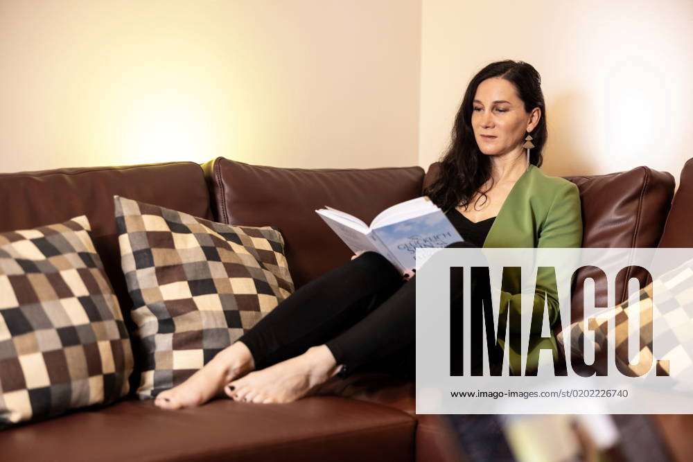 Eine Reifere Frau Liest Auf Einer Couch In Einem Buch Model Released