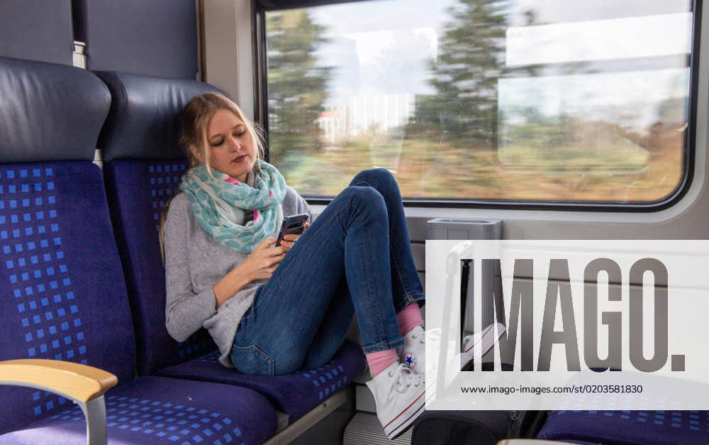 Junge Frau Im Zug Blickt Auf Ihr Smartphone Model Released Young Woman On Train Looking At Her 