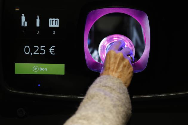 Dusseldorf, Germany, 02 03 2023 A woman puts empties into the shaft of ...