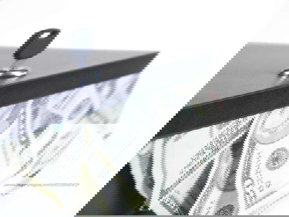 Lockbox with US bills sticking out with key in box. shallow depth of