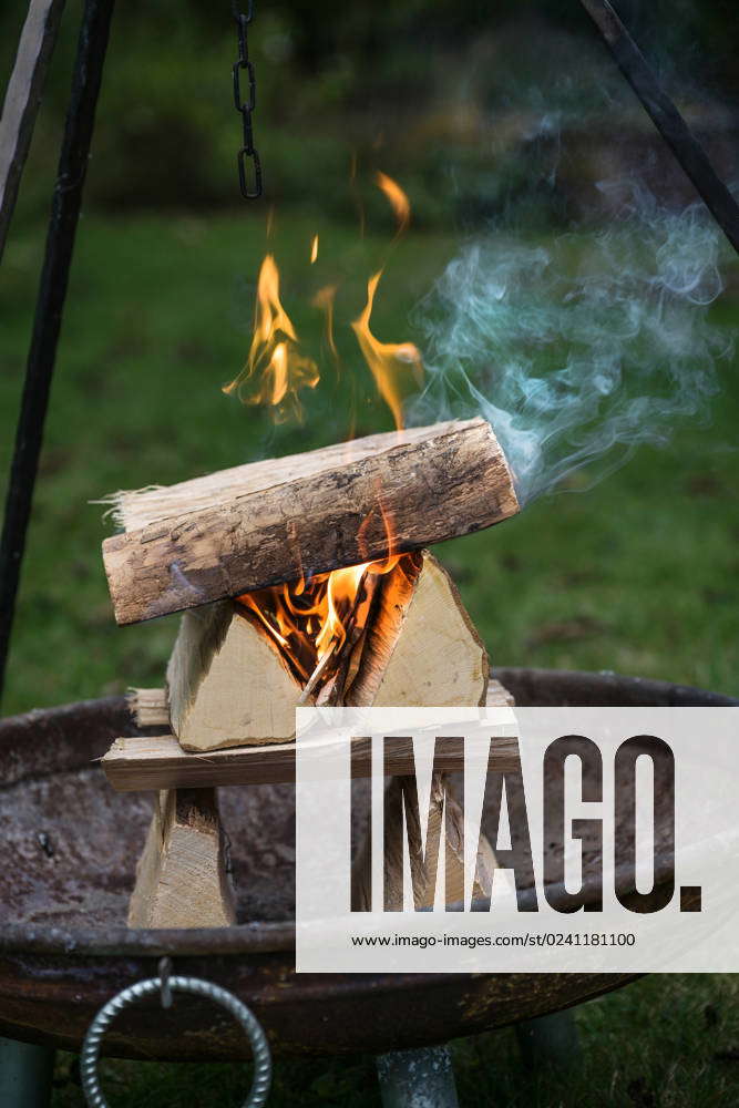 Skillfully arranged logs of firewood logs burning with flames and smoke