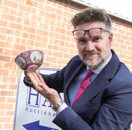 This image shows: Auctioneer Charles Hanson with the remarkable finds ...