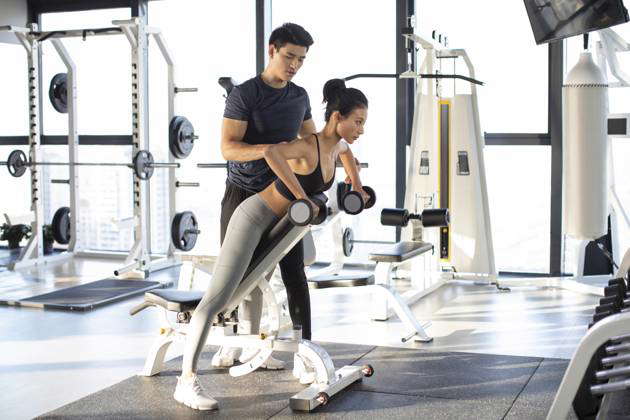 Young Chinese woman working out with personal trainer at gym Beijing China