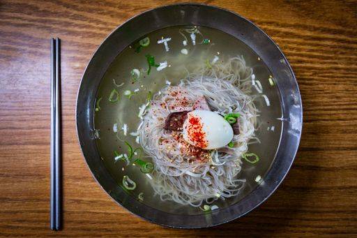 A top view of plate of pyongyang naengmyeon noodles and chopsticks on ...