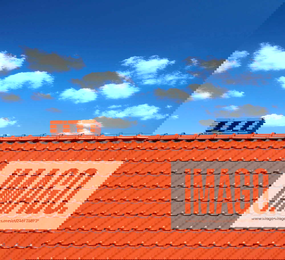 Red roofingtiles with cumulus clouds above