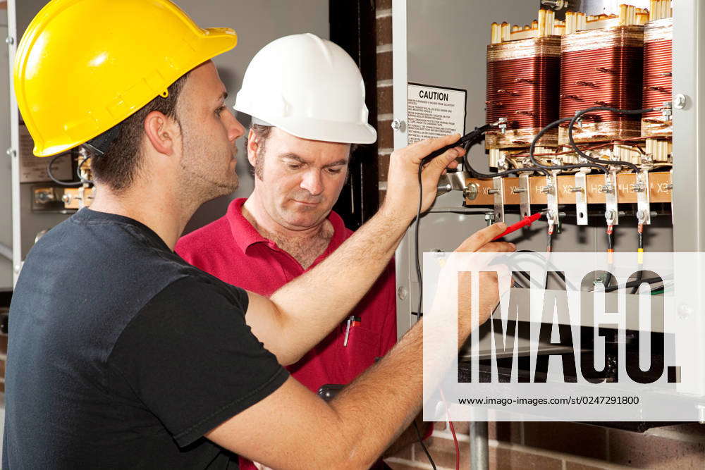 Apprentice electrician works on an industrial power distribution center ...