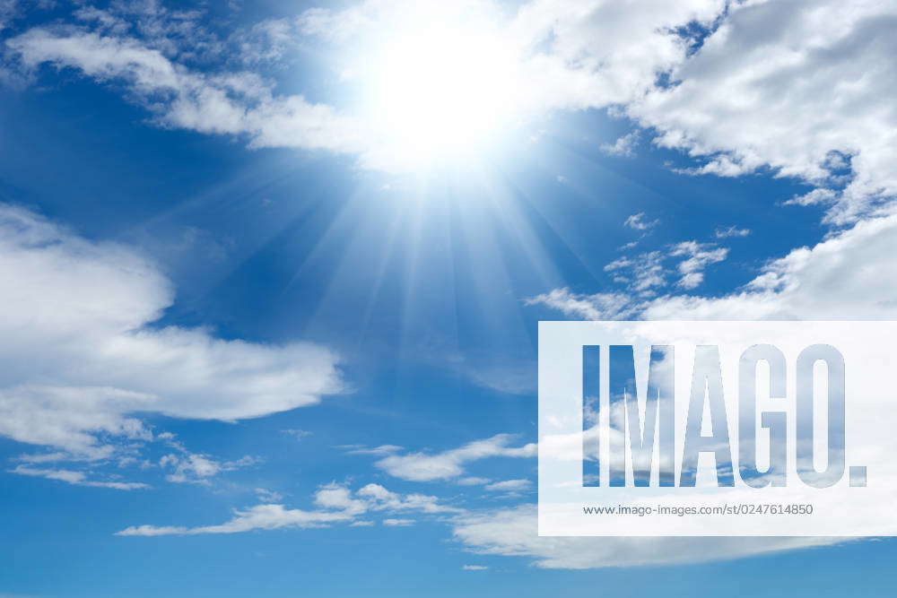 Bright sun shines through clouds in the blue