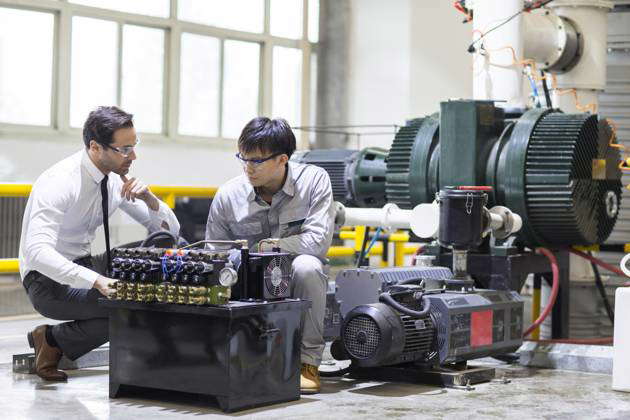 Businessman and engineer checking machine in the factory Beijing