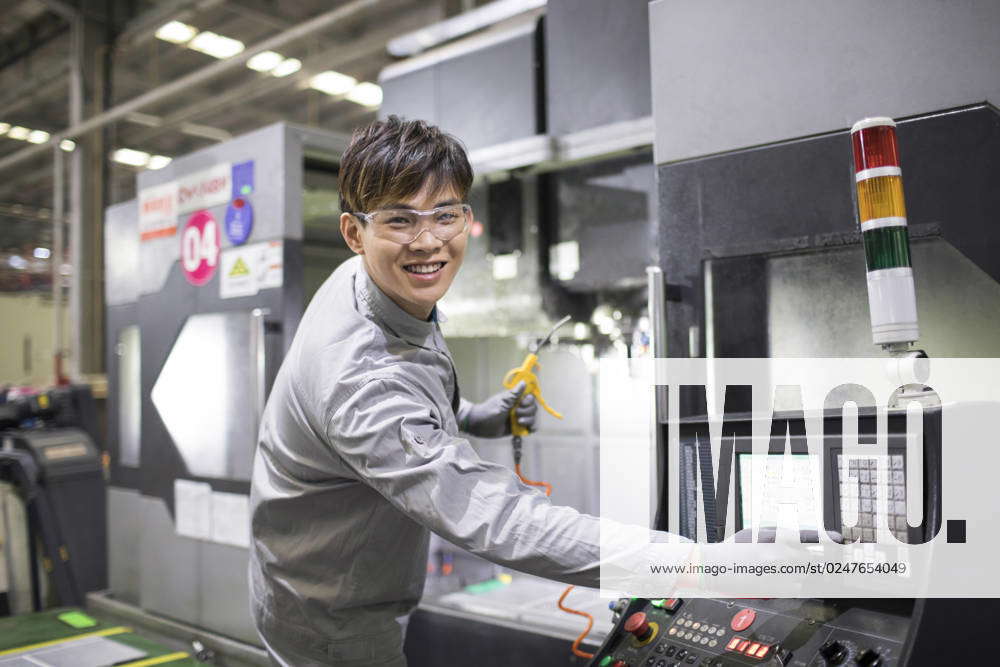 Confident Chinese engineer working in the factory Beijing China