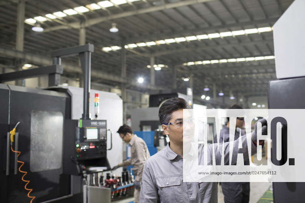 Confident Chinese engineers working in the factory Beijing